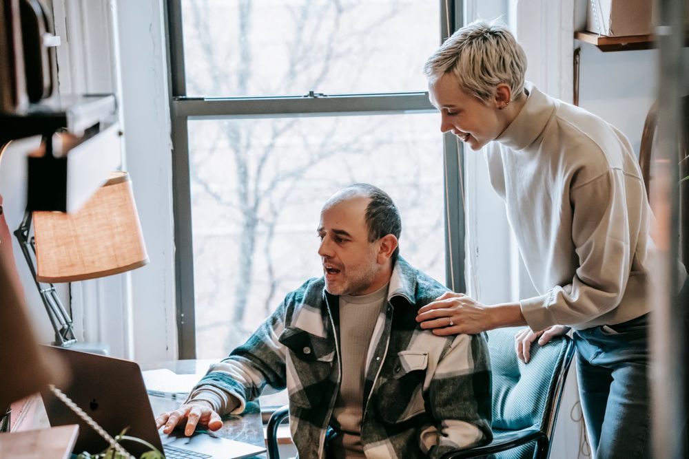 Colleagues working together on a laptop in a small office